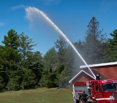 Fire vehicle with turret gun shooting water high into the air